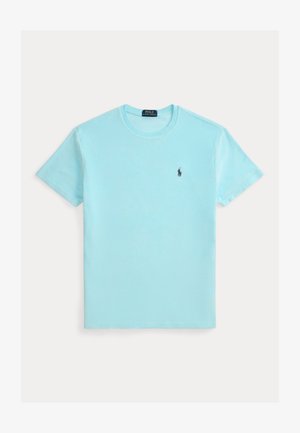 Světlé modré tričko s krátkým rukávem a kulatým výstřihem, s malým tmavým logem hráče polo na levé straně hrudi.