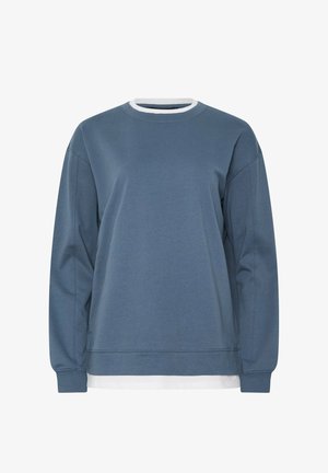 Blauwe trui met lange mouwen en een ronde hals, gedragen over een wit shirt, met geribbelde manchetten en een losse pasvorm.