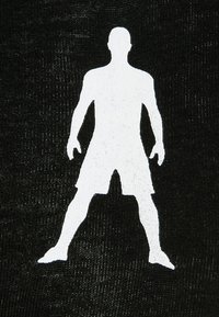 Hvid silhuet af en stående figur på en sort tekstureret baggrund, der viser arme og ben i en atletisk positur.