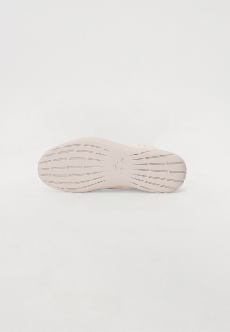 Semelle de sneaker Lacoste en caoutchouc rose pâle avec texture rainurée et motifs linéaires pour l'adhérence. Détails du logo en relief.