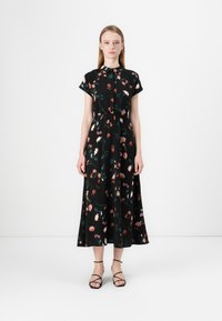 Robe maxi noire à manches courtes et évasées, avec un motif floral en rose et vert. Ceinturée à la taille, fabriquée en matériau léger.