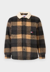 Button-up fleece shirt in black and tan check pattern. Features a cream sherpa collar and two front pockets. Soft texture throughout.