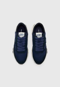 Navy blue sneakers with a textured fabric upper, round toe, and thick sole. Features lace-up design and GANT branding on the tongue.