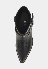 Czarne skórzane buty za kostkę z ostrym noskiem, dekoracyjnym przeszyciem i metalowymi akcentami w okolicy kostki. Gładka faktura, elegancki design.