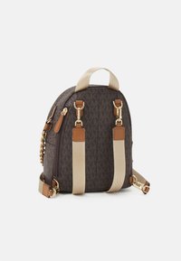 Brauner Rucksack mit gemustertem Design, hellbraunen Lederakzenten, goldenen Beschlägen und beigen Trägern. Er hat eine schlanke Form mit einem oberen Tragegriff und einem Reißverschluss.