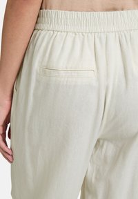 Lichtbeige, linnenmix broek met een elastische tailleband, zijzakken en een enkele achterzak met een platte naad.