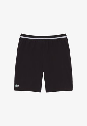 Pantalones cortos deportivos negros con una cintura elástica blanca y negra y un pequeño logotipo de cocodrilo verde en el dobladillo de la pierna izquierda.
