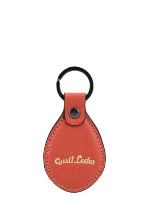 Llavero en forma de lágrima de cuero rojo con botón negro y anilla metálica, con relieve con "Gusti Leder" en letras doradas.