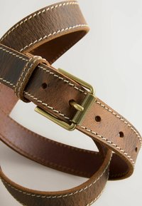 Bruine leren riem met een gestructureerde afwerking, gespen van metaal in goudkleur en witte stiksels. Voorzien van meerdere gaten voor een verstelbare pasvorm.