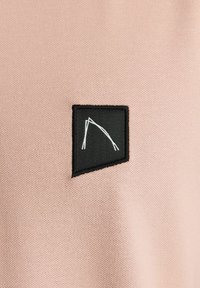 Šviesiai rožinė medžiaga su juodu stačiakampiu pleistru, ant kurio balta minimalistinė linijų piešinys arko forma. Lygi tekstūra, paprastas dizainas.