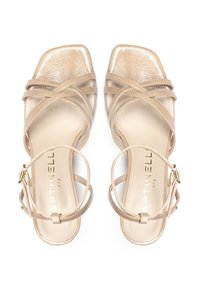 Sandalias de tacón alto con tiras en un acabado patent en tono nude, con tiras entrecruzadas y diseño de punta cuadrada. Logo de la marca visible en la plantilla.