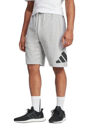 Grijze sportshorts gemaakt van zachte stof, met een zwart logo-ontwerp met drie strepen, een elastische tailleband en zijzakken.