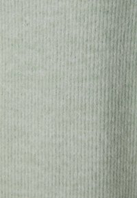 Tessuto a coste di un verde chiaro con una morbida trama, caratterizzato da linee verticali e un delicato lucido. Ideale per abbigliamento o tappezzeria.
