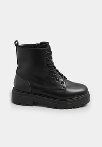 Stivaletto in pelle nera con lacci, punta rotonda, suola in gomma spessa e linguetta sul retro per indossarlo facilmente. Texture piatta, aspetto robusto.