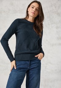 Maritimer Strickpullover mit strukturierten Rautenmuster, gerippten B�ündchen und Saum, kombiniert mit blauen Jeans. Weiches, luxuriöses Material.