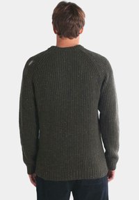 Suéter de punto verde oscuro con textura acanalada, que presenta un cuello redondo y mangas raglán. Sutiles motas de color a lo largo.