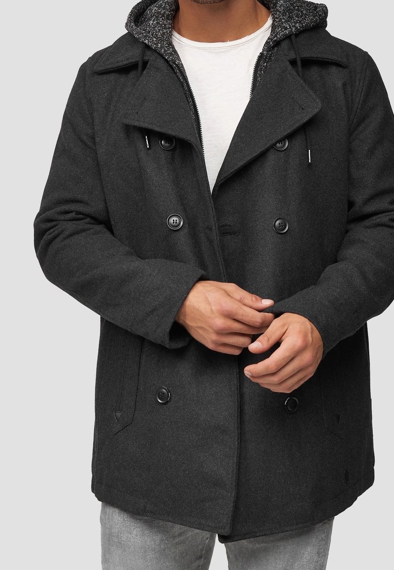 Parka doppiopetto in misto lana grigio scuro con grandi bottoni e cappuccio con coulisse e fodera interna strutturata.