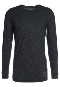 Långärmad skjorta i svart heathered tyg, med rundad hals och subtil textur, samt en liten logotyp på nedre vänstra sidan.