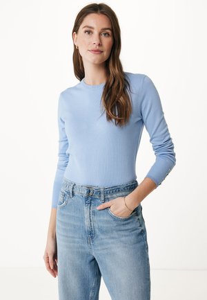 Pull ajusté bleu clair à manches longues, texture côtelée et accents de boutons aux poignets, associé à un jean en denim clair taille haute.