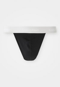 Schwarzer Baumwollstring mit einem grauen elastischen Taillengummi, auf dem das "Calvin Klein"-Logo in Weiß abgebildet ist. Glatte Textur und minimalistisches Design.