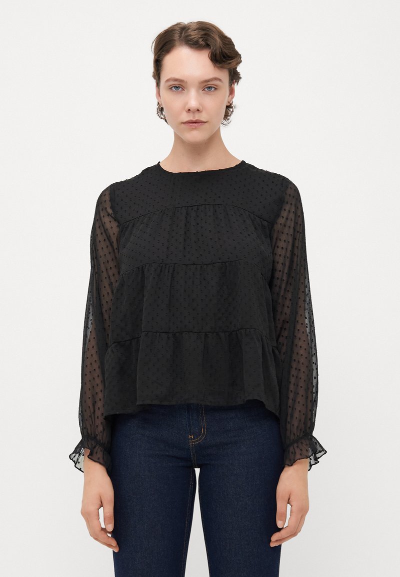 Schwarze, gestufte Bluse aus transparenter Stoff mit gepunkteter Textur. Verfügt über lange, leicht geraffte Ärmel und einen runden Ausschnitt.