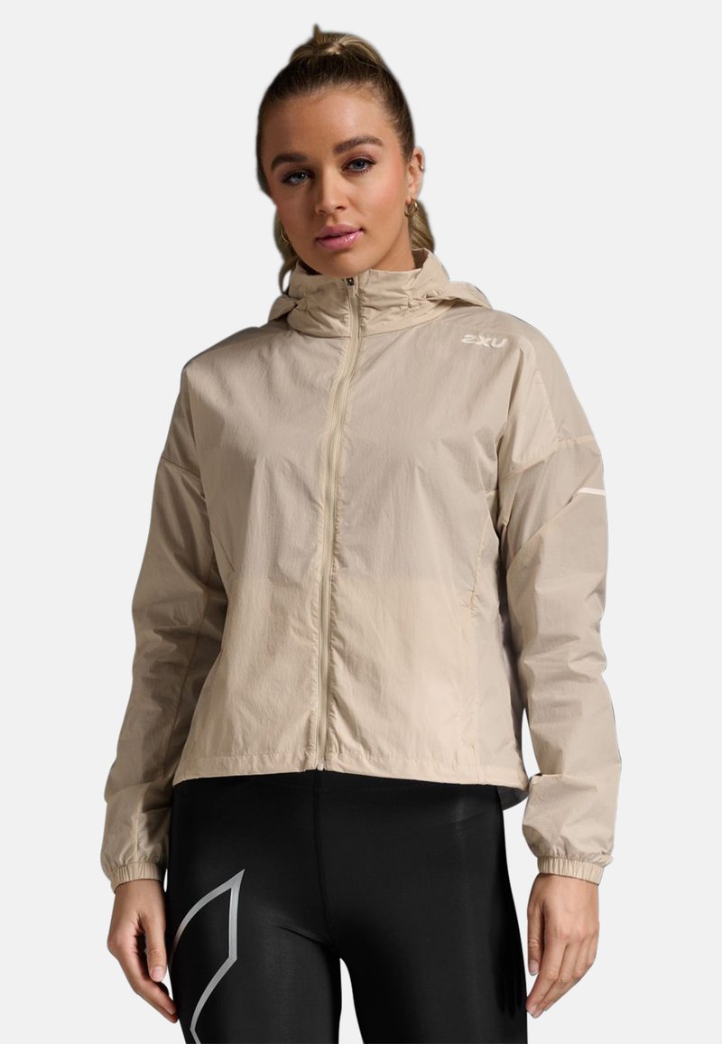 Beige leichte Jacke mit Kapuze, Reißverschluss vorne, elastischen Bündchen und schlichtem Design; präsentiert ein dezentes Logo auf der Brust.