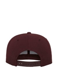 Bordo snapback müts tekstureeritud kangast, kumer äärega ja taga reguleeritava plastistsriga, millel on mitu suuruse soonte kohta.