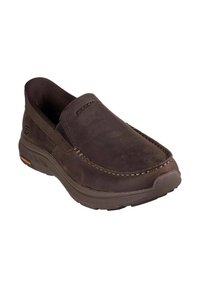 Scarpa slip-on in pelle marrone con pannelli elastici laterali, suola in gomma e dettagli di cucitura a contrasto. Presenta il logo Skechers sul lato.