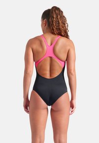 Sort én-delt badedragt med en pink racerback-design, der har et udskåret ryg og en glat tekstur. Justerbare stropper og ingen synlige mønstre.