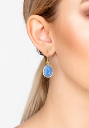 Goldfarbene Anhängerohrringe mit einem tropfenförmigen, facettierten blauen Edelstein. Das Design enthält einen einfachen Haken für sicheren Halt.
