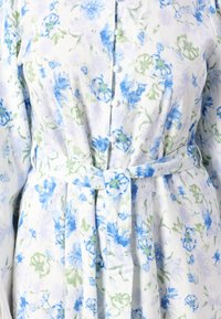 Vestido floral com padrões de flores azuis e verdes sobre um fundo branco, com frente abotoada e cintura cintada para uma silhueta ajustada.