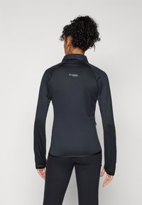Black athletic jacket with a textured pattern, high collar, long sleeves, and a zippered pocket, featuring a small logo on the back.
