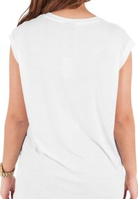 Tricou alb cu mânecă scurtă, cu un croi lejer, textură fină și decolteu rotund. Cusături vizibile pe spate și fante laterale pentru confort.