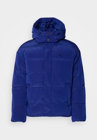 Blå puffjakke med høy krage og justerbar hette. Har quiltet design og subtil merkevare på brystet. Myk, teksturert stoff.