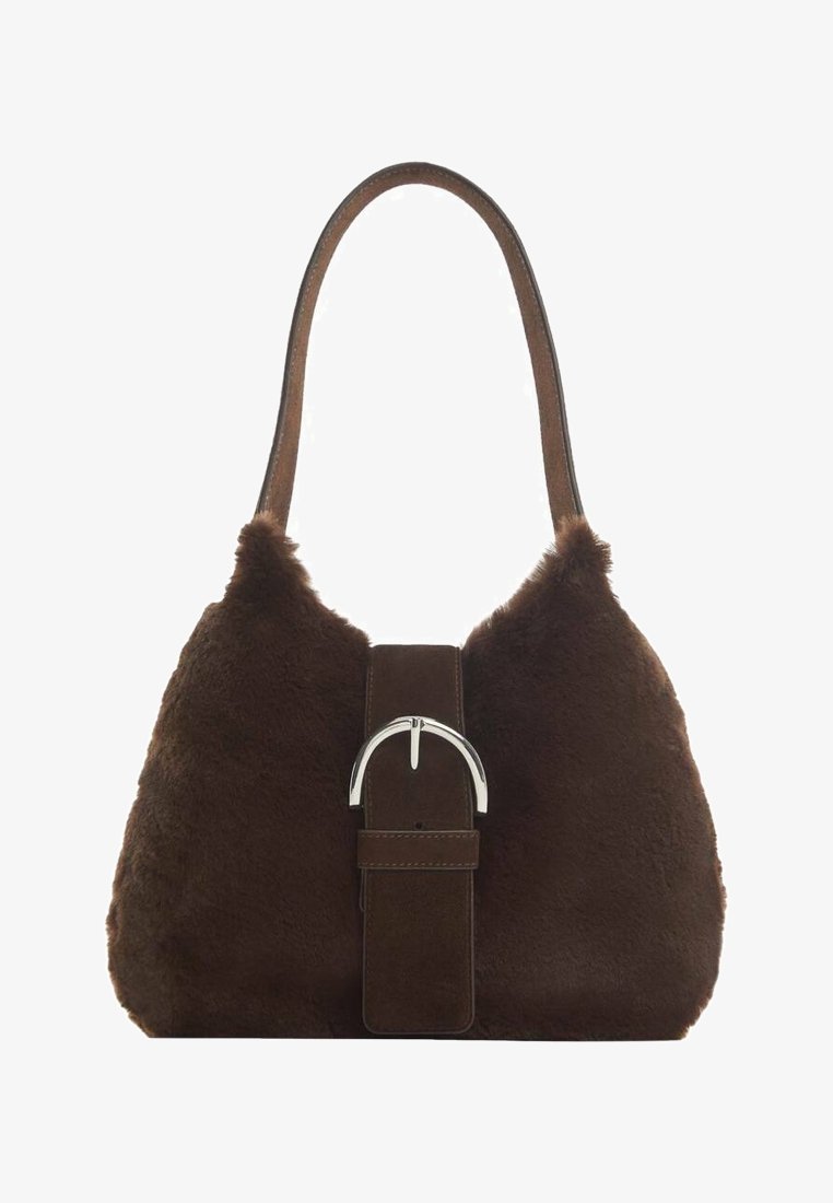 Sac à épaule marron en fausse fourrure avec une large bandoulière en suède et une grande boucle argentée au centre.