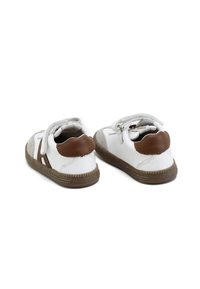 Zapatos de cuero blanco con acentos marrones y parches de ante gris, con cordones y suelas de goma texturizadas.