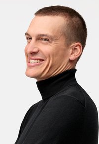 Schwarzer gestrickter Rollkragenpullover mit gerippter Textur, enganliegendem Design und dezenten Schulternähten, getragen von einer lächelnden Person.