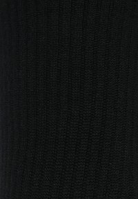 Tessuto a maglia nera con texture a righe verticali, aspetto morbido e colore uniforme. Non sono visibili altri motivi o segni.