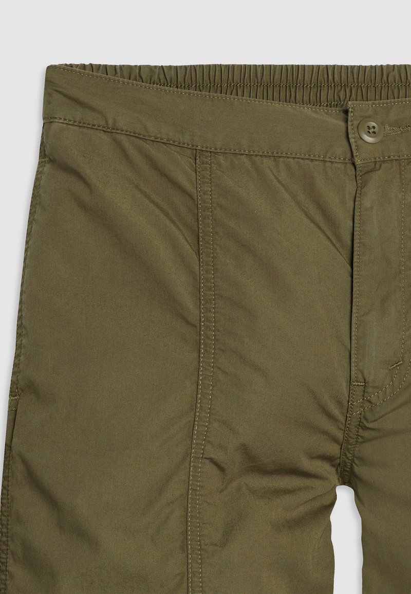 Pantalons vert olive avec une taille élastique, fermeture à bouton, coupe droite et poches latérales. Le tissu a une texture lisse.