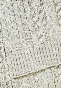 Pull en laine côtelée gris clair avec des motifs texturés en torsades et des designs côtelés, présentant des motifs variés et une apparence douce et épaisse.