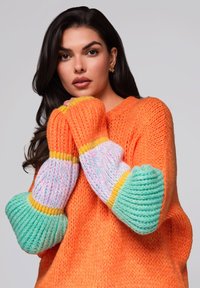 Helles orange gestricktes Sweatshirt mit übergroßen, mehrfarbigen Ärmeln, die mintgrüne, pastellpinkfarbene und gelbe Streifen aufweisen. Strukturiertes Finish.