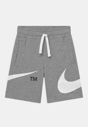 Grau melierte Shorts mit Kordelzug, Seitentaschen und großen weißen Nike-Swoosh-Logos auf jedem Bein, mit "TM" auf dem linken Bein gekennzeichnet.