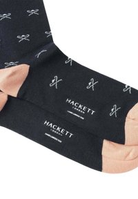 Mørkeblå sokker med lys blå sløjfemønster, rosa tådetaljer og et logo-label. Materialet ser glat og elastisk ud, velegnet til hverdag.