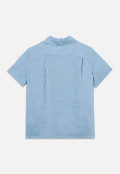 Ανοιχτό μπλε πουκάμισο με κοντά μανίκια, γιακά, πτυχώσεις στην πλάτη και ύφασμα ώμου, εμφανίζεται από πίσω σε λευκό φόντο.