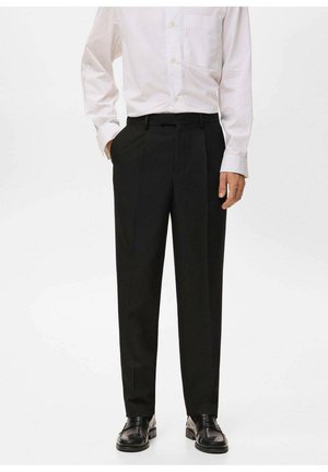 Pantalones negros ajustados con un diseño de pierna recta, confeccionados en una tela suave; cuentan con pasadores para cinturón y pliegues frontales, combinados con zapatos pulidos.