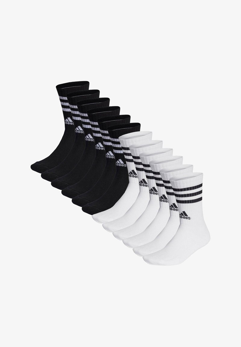 Docenas de pares de calcetines de equipo en negro y blanco; los calcetines negros tienen tres franjas blancas y el logo de 'adidas', mientras que los calcetines blancos tienen un diseño similar.
