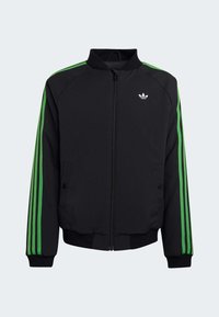Svart sportjacka med grön tre-randsdesign på ärmarna, dragkedja, sidofickor och ribbade muddar och nederkant. Har logotyp på bröstet.