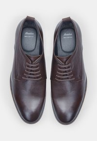 Pantofi de dress din piele maro cu un finisaj neted, design cu șireturi și vârf rotund. Au cusături subtile și o talpă contrastantă.