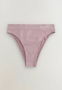 Ljust rosa bomullsstringtrosor med en mjuk textur, ett brett midjeband som har ordet "self." i vitt och en minimalistisk design.