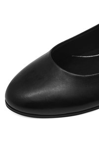 Schwarze Leder-Ballerinas mit runder Zehenpartie, glatter Textur und niedriger Profil. Minimalistisches Design ohne sichtbare Akzente.